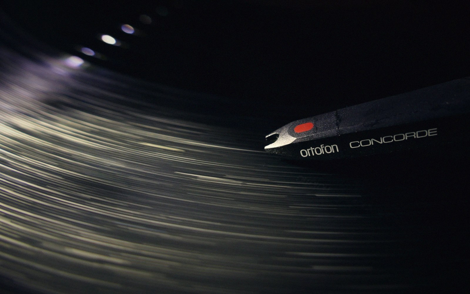 An Ortofon Concorde turntable cartridge tracking a spinning record with motion-blurred grooves